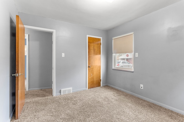 unfurnished bedroom featuring carpet floors, visible vents, and baseboards