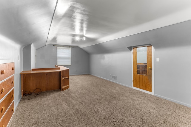 additional living space featuring lofted ceiling, carpet flooring, visible vents, and baseboards