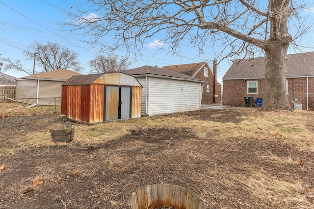 exterior space with a storage shed, an outbuilding, and fence