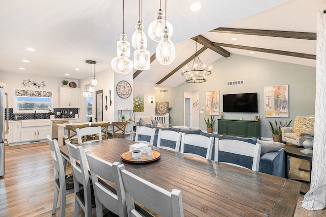 dining room featuring recessed lighting, visible vents, lofted ceiling with beams, an inviting chandelier, and light wood-style floors