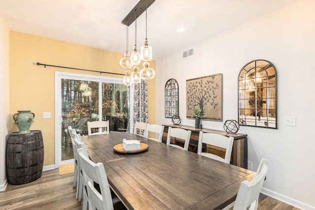 dining room featuring baseboards, visible vents, and wood finished floors