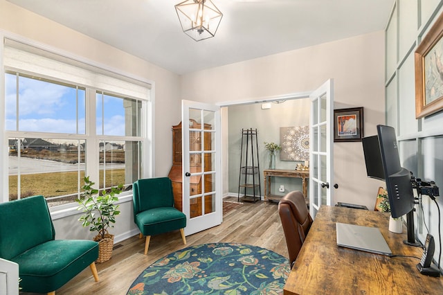 office space featuring baseboards, french doors, wood finished floors, and a notable chandelier