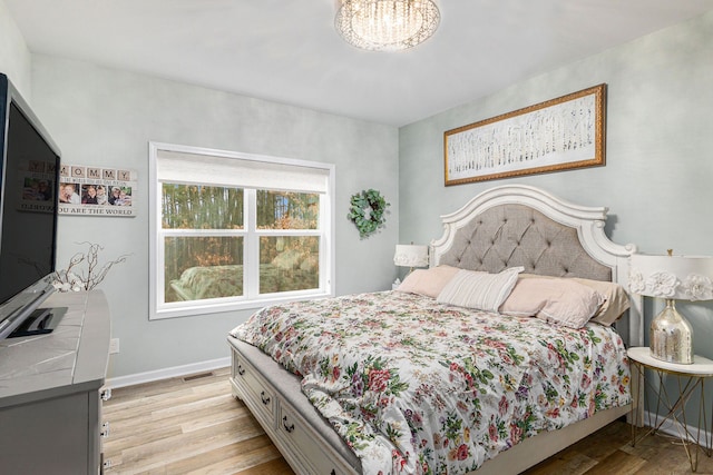 bedroom featuring baseboards, visible vents, and light wood-style floors