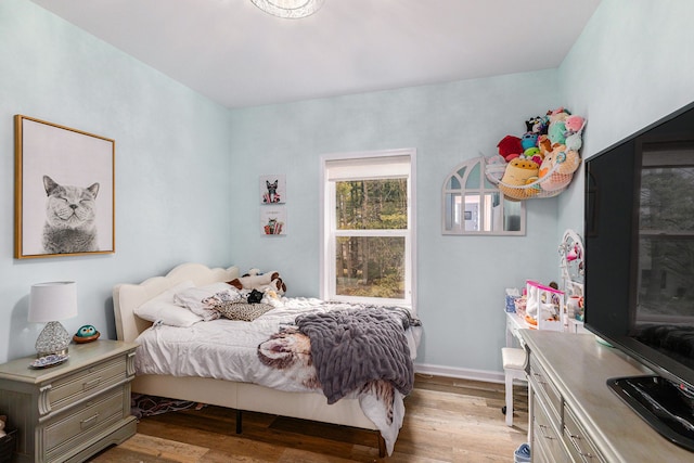 bedroom with baseboards and wood finished floors