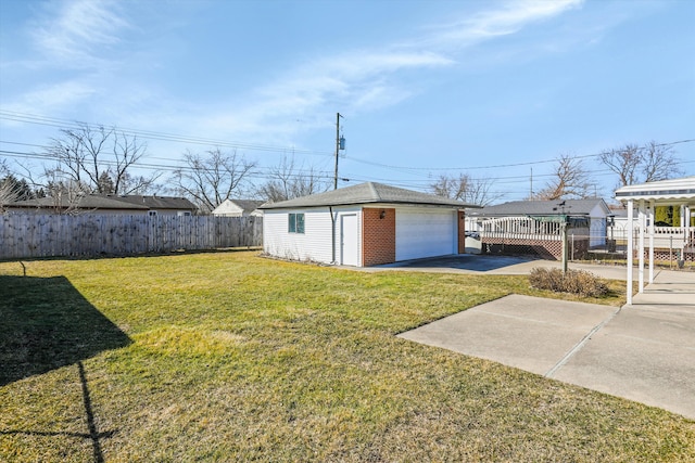 view of yard featuring a detached garage, fence, and an outdoor structure