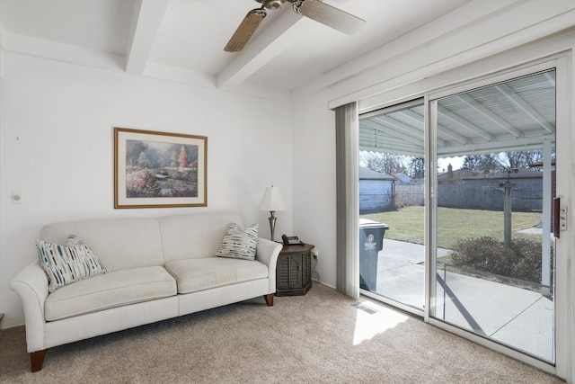 living room featuring beamed ceiling, visible vents, a ceiling fan, and carpet