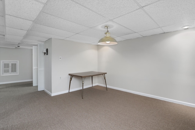 finished below grade area featuring visible vents, carpet, baseboards, and a paneled ceiling