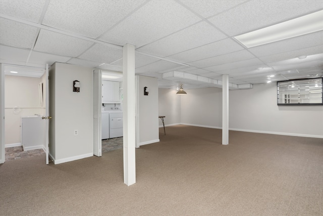 finished basement featuring washer / clothes dryer, carpet, baseboards, and a drop ceiling