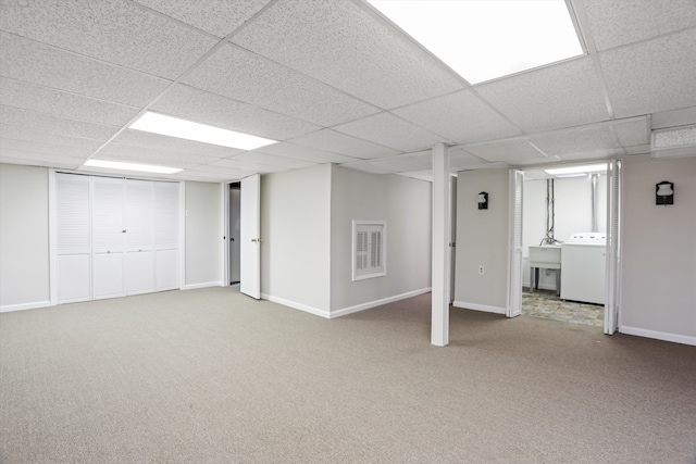 finished basement featuring a sink, baseboards, washer / clothes dryer, and carpet