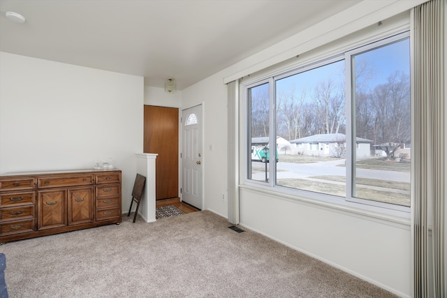 carpeted empty room featuring visible vents