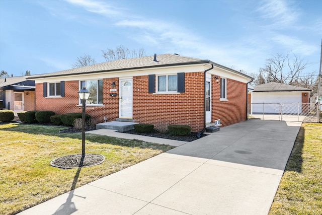 view of front of home featuring fence, an outdoor structure, a front yard, a garage, and brick siding