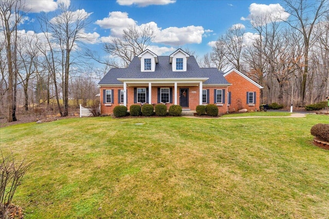 view of front facade featuring a shingled roof, a porch, a front lawn, and brick siding