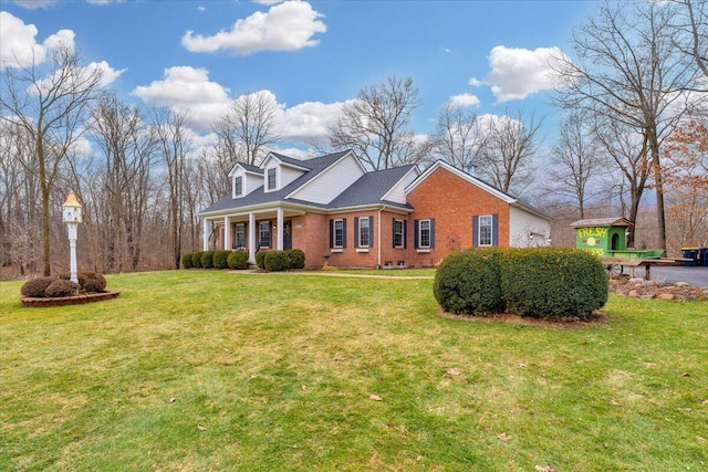 view of front of home featuring a front yard, a porch, and brick siding