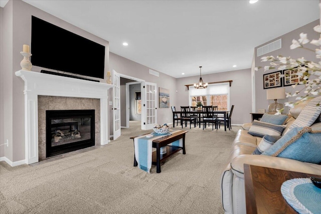 living room with a tiled fireplace, visible vents, carpet flooring, and recessed lighting