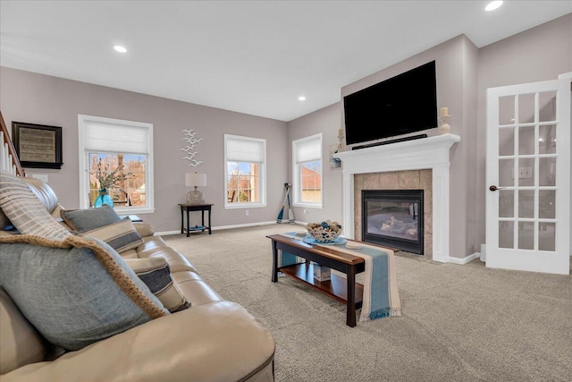 carpeted living area featuring baseboards, a tile fireplace, and recessed lighting