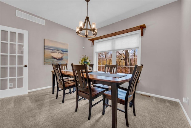 dining area featuring a chandelier, light carpet, visible vents, and baseboards