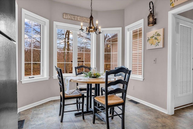 dining area with visible vents, baseboards, and an inviting chandelier