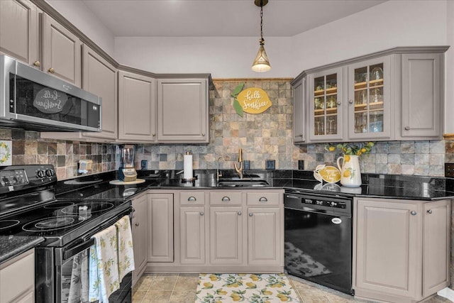 kitchen with glass insert cabinets, backsplash, gray cabinets, black appliances, and a sink