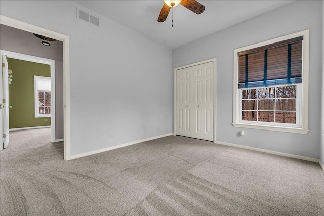 unfurnished bedroom with carpet floors, a ceiling fan, visible vents, baseboards, and a closet