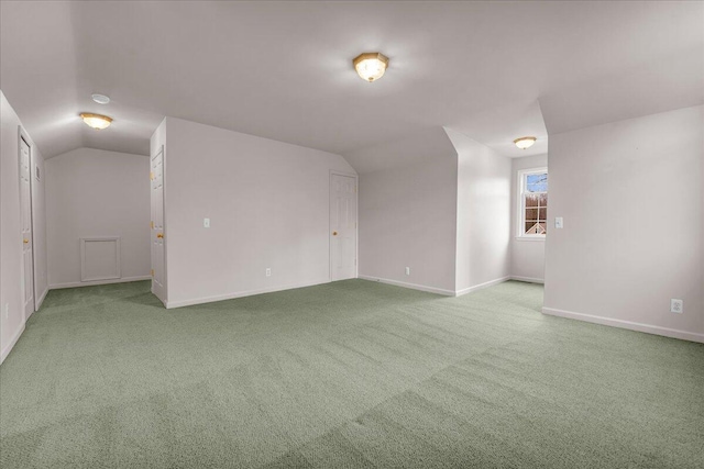 interior space with carpet, vaulted ceiling, and baseboards