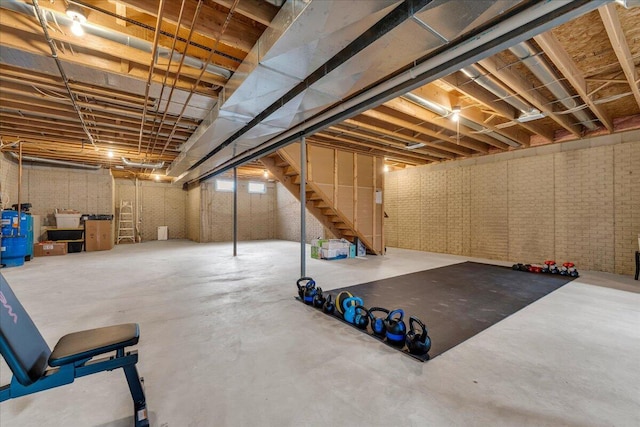 basement with brick wall and stairs