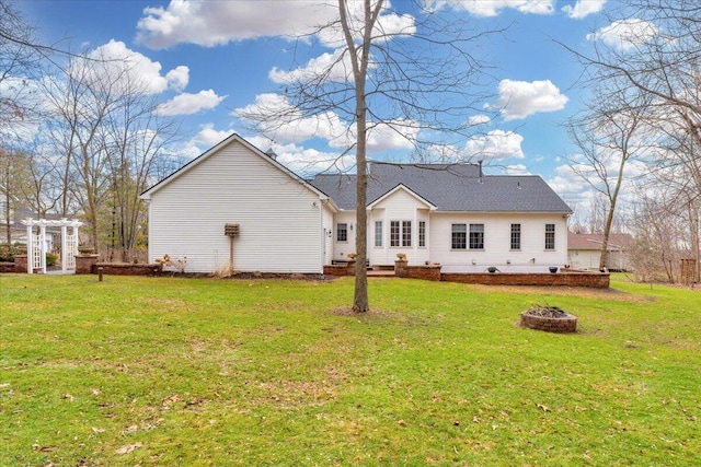 rear view of house with a lawn, a fire pit, and a pergola