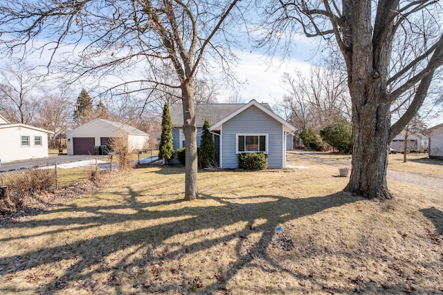 exterior space with a garage, an outdoor structure, and a front yard