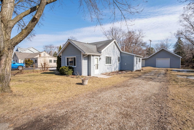 view of front of house featuring a garage, dirt driveway, fence, an outdoor structure, and a front lawn