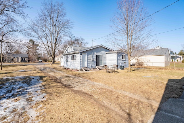 exterior space with entry steps, fence, and a front yard