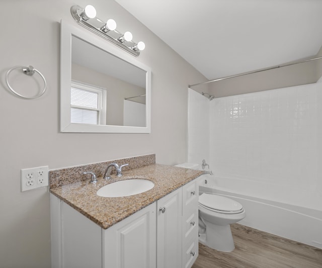 bathroom featuring tub / shower combination, vanity, toilet, and wood finished floors