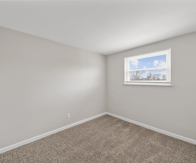 carpeted empty room with baseboards