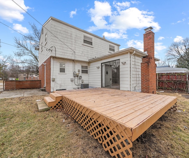 rear view of property with fence, a chimney, and a wooden deck