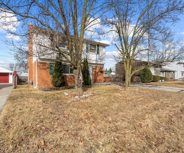 view of front of house featuring an outdoor structure, brick siding, fence, and a front lawn