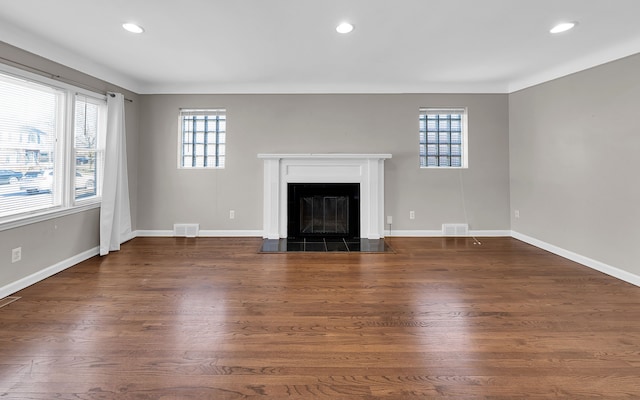 unfurnished living room featuring a glass covered fireplace, recessed lighting, and baseboards