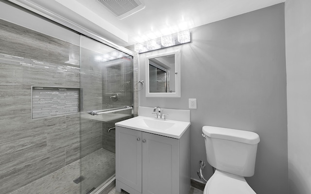 bathroom with vanity, toilet, visible vents, and a stall shower