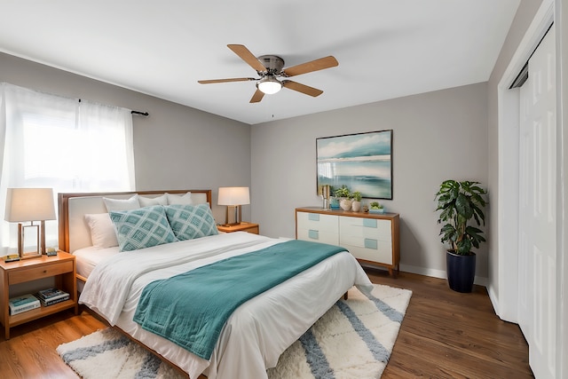 bedroom featuring a closet, a ceiling fan, baseboards, and wood finished floors