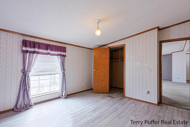 unfurnished bedroom featuring wallpapered walls and crown molding