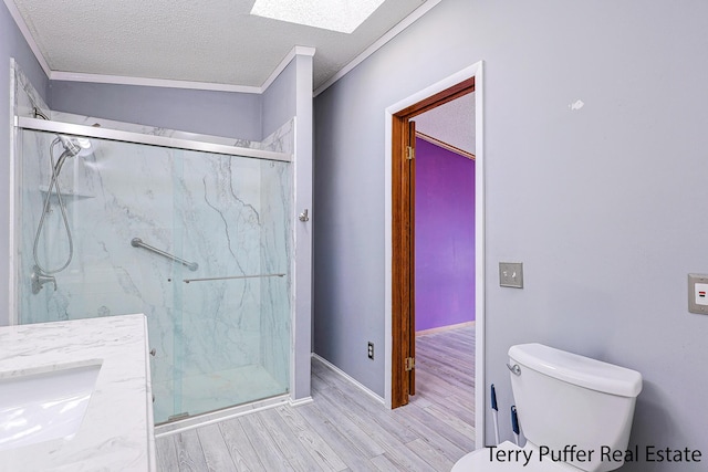 full bath with a textured ceiling, wood finished floors, a marble finish shower, and toilet