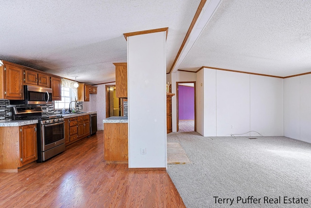 kitchen featuring a textured ceiling, light countertops, appliances with stainless steel finishes, and a sink