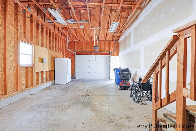 garage with freestanding refrigerator and a garage door opener