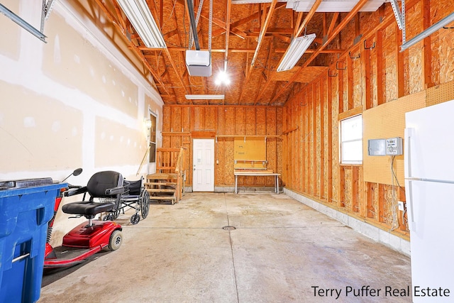 garage featuring freestanding refrigerator and a garage door opener