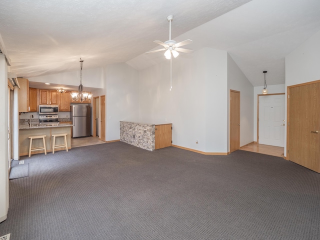 unfurnished living room featuring high vaulted ceiling, light carpet, ceiling fan with notable chandelier, a sink, and baseboards