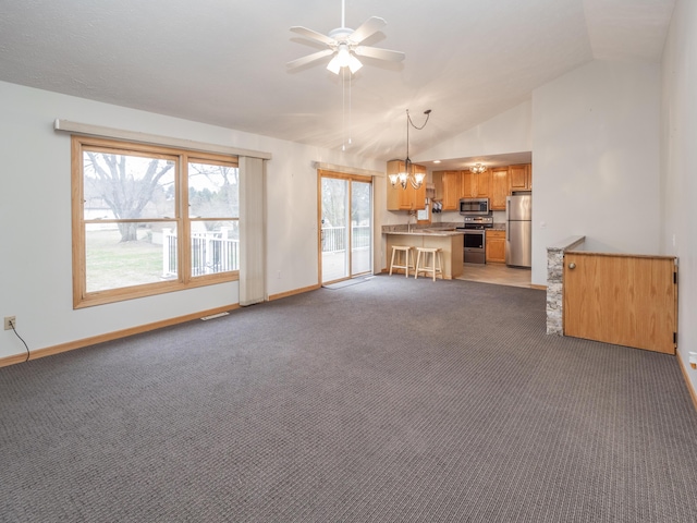 unfurnished living room with lofted ceiling, ceiling fan with notable chandelier, baseboards, and light colored carpet