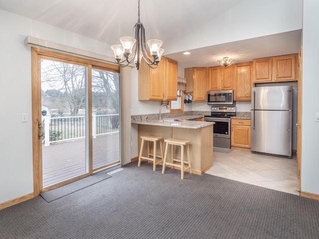 kitchen featuring light stone counters, light carpet, stainless steel appliances, a peninsula, and vaulted ceiling