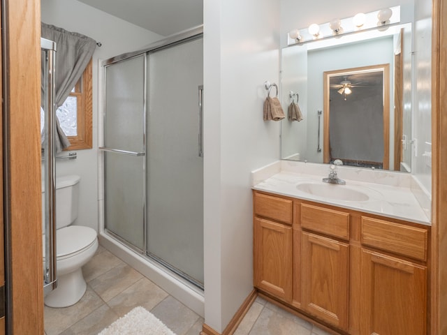 bathroom with a stall shower, vanity, toilet, and tile patterned floors