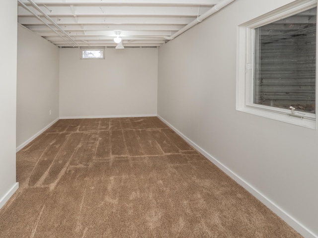 below grade area featuring carpet and baseboards