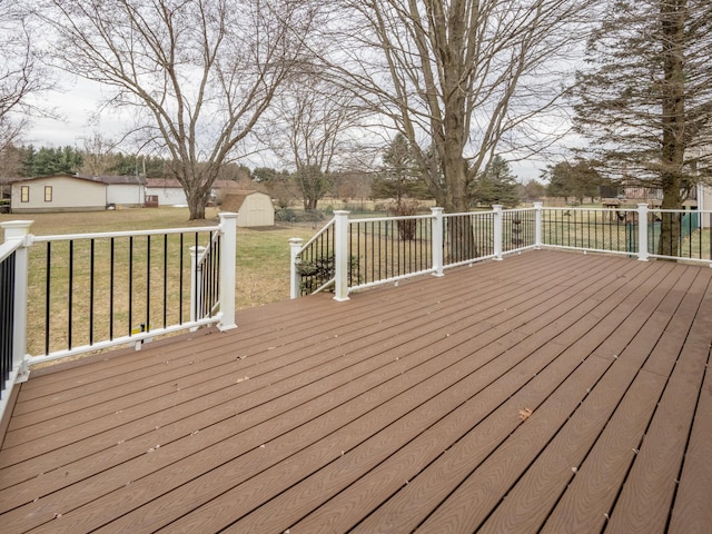 deck featuring a shed, a lawn, and an outdoor structure