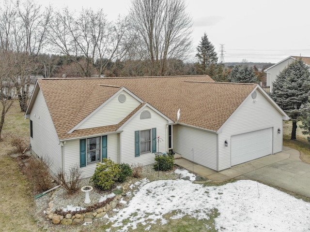 single story home with concrete driveway, roof with shingles, and an attached garage