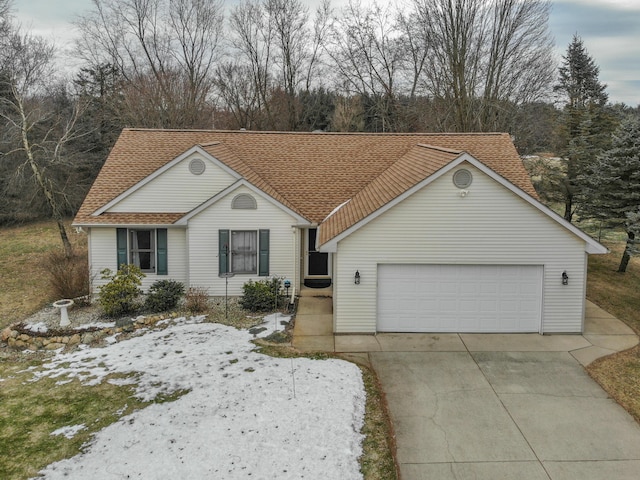 single story home featuring a shingled roof, concrete driveway, and an attached garage