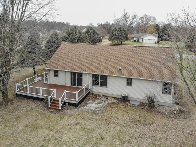 rear view of property featuring a yard, a shingled roof, a wooden deck, and central air condition unit